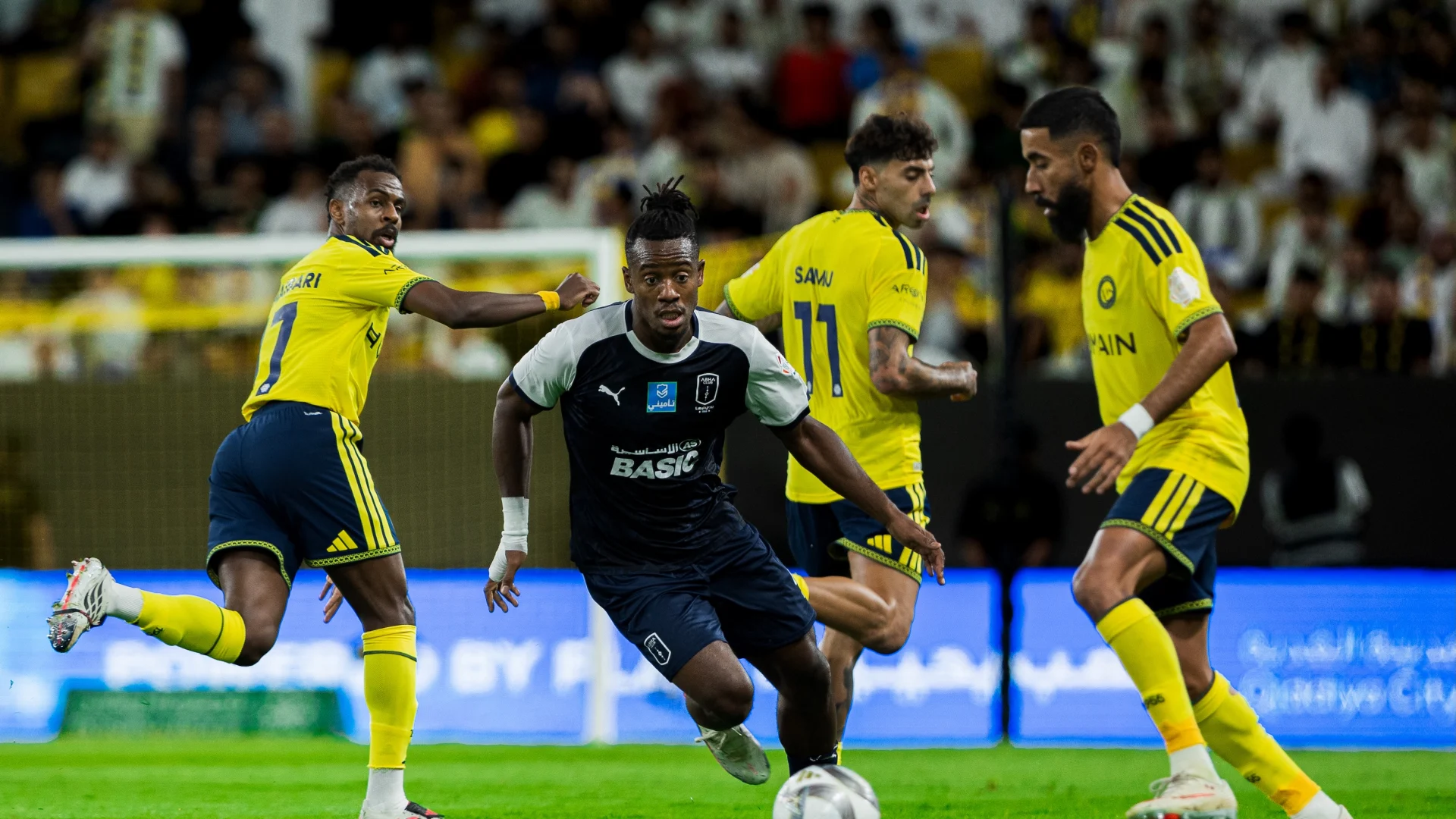 Renowned Abha striker Michy Batshuayi escapes from a clutch of Al Nassr players