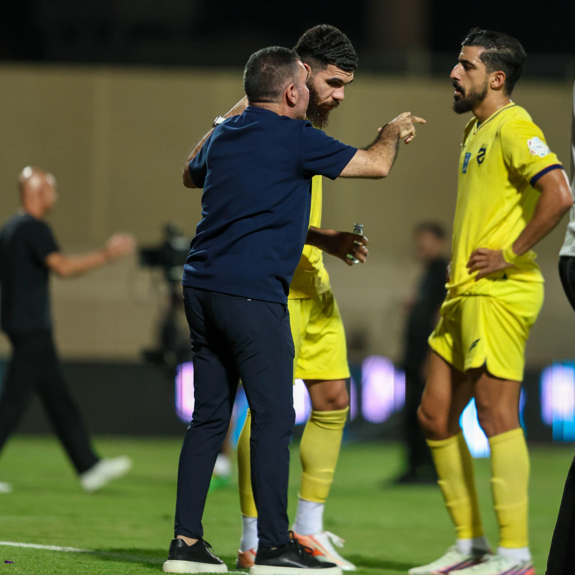 محمد بن حميدة يستمع مع زميله سلطان تنكر لتوصيات مدربهم جلال قادري في مباراة الشباب